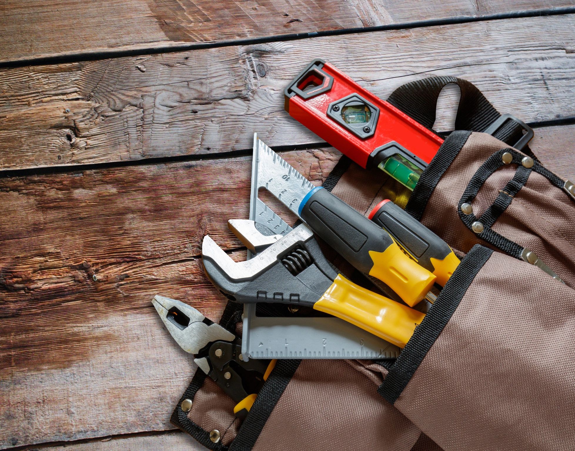 Contractor measuring and hand tools on wood background